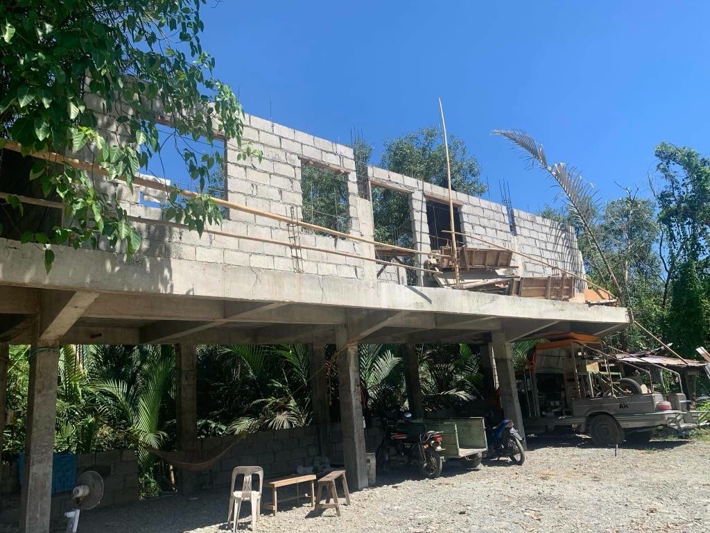 The concrete frame standing on its posts with the first courses of blockwork on the elevated slab