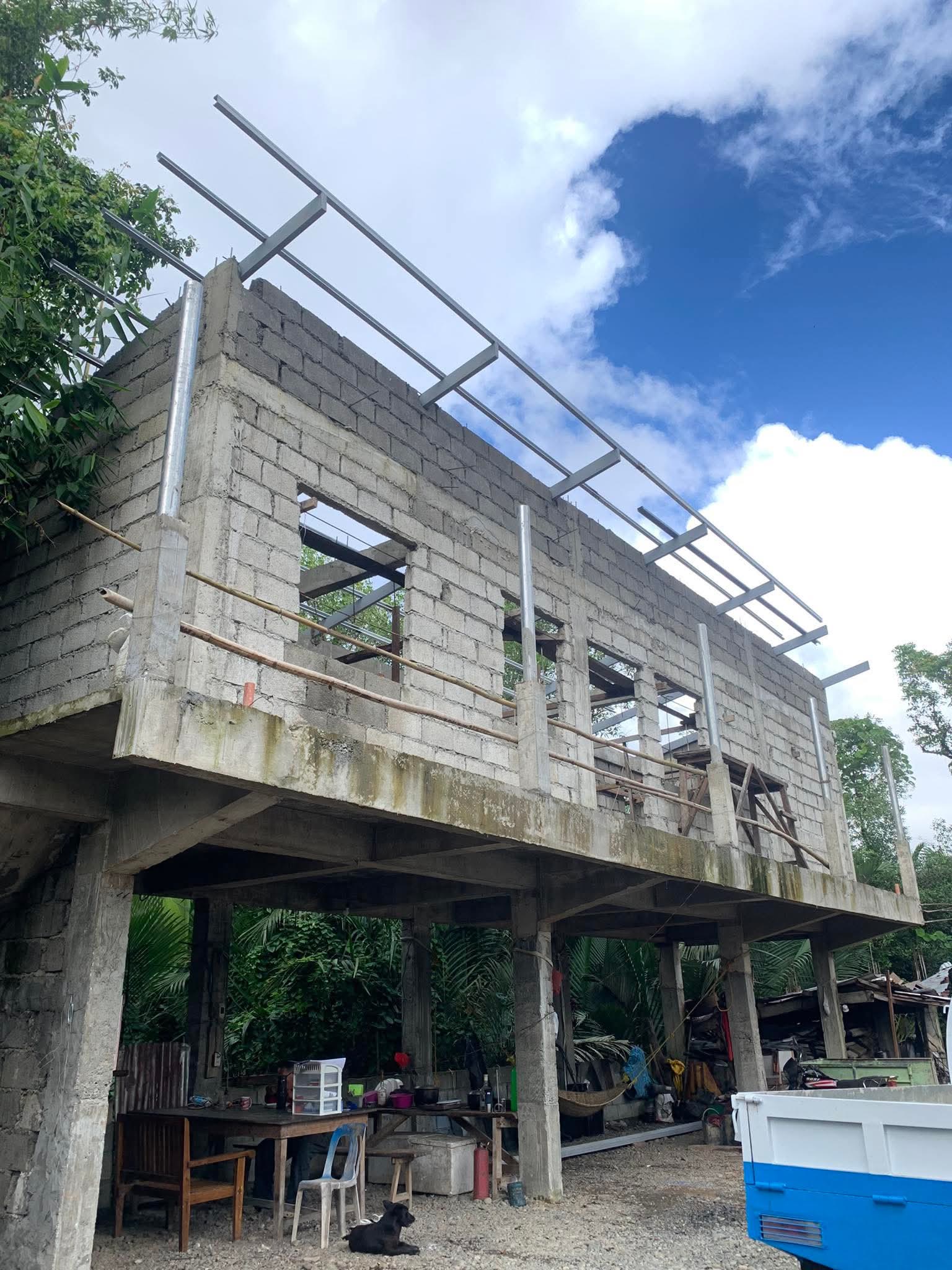 Steel purlins spanning the top of the blockwork against an open sky