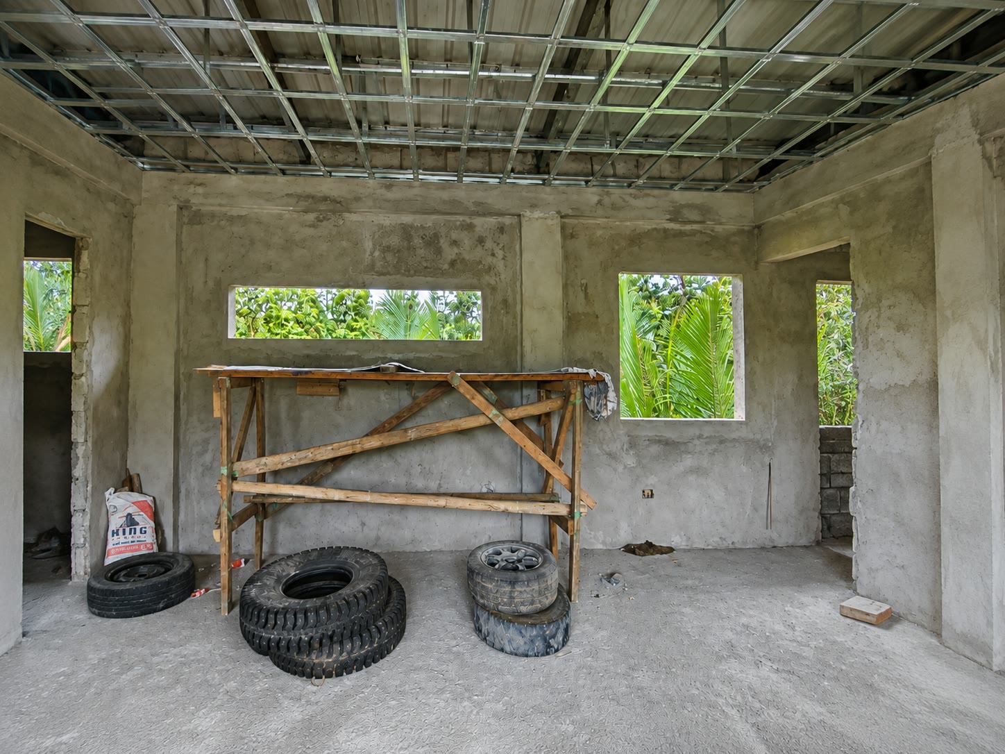 The main interior space with the steel ceiling grid installed and a timber trestle standing in the middle