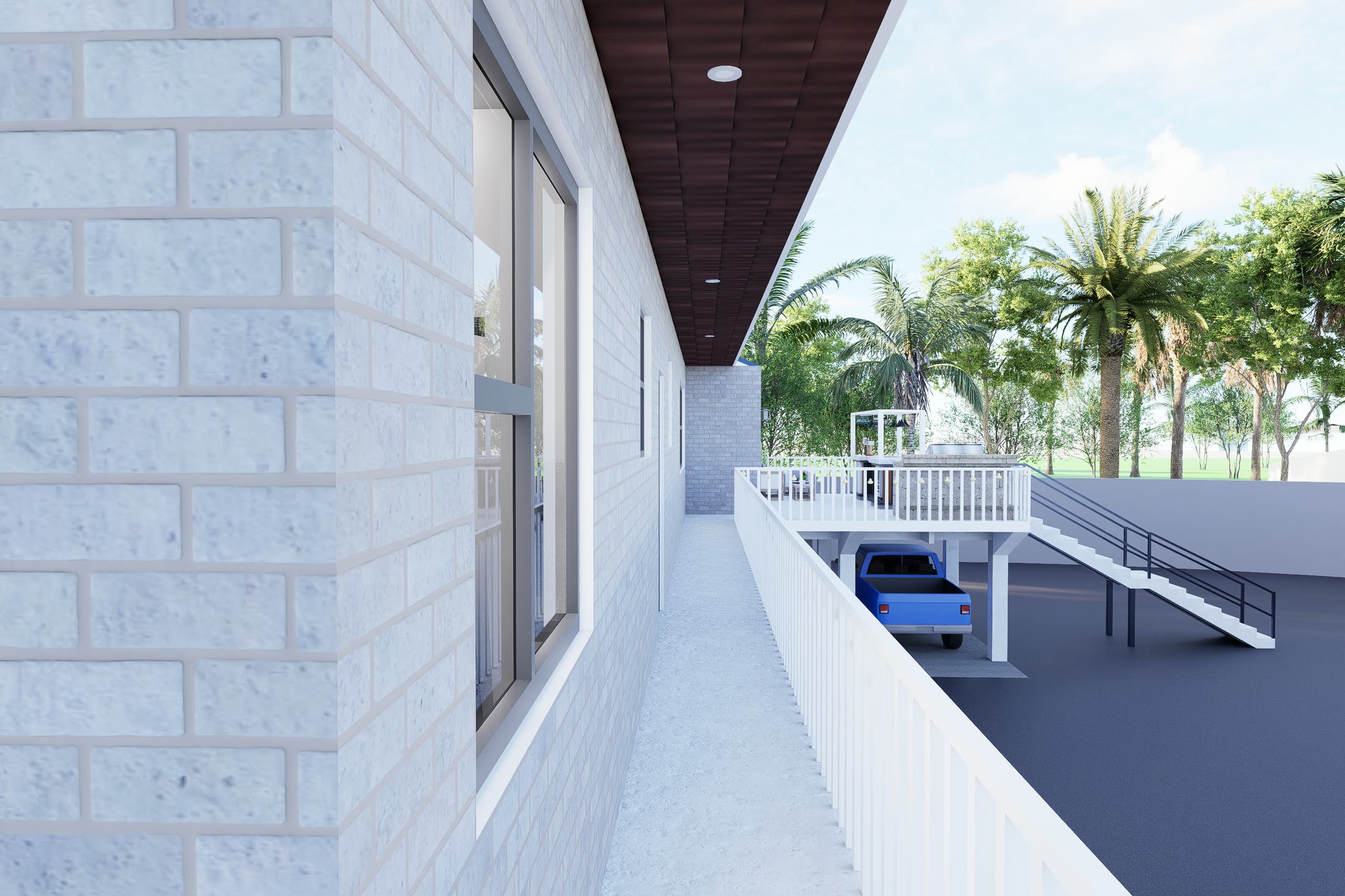 The walkway running between the brick wall of the house and its railing, opening out to palms and the lot beyond