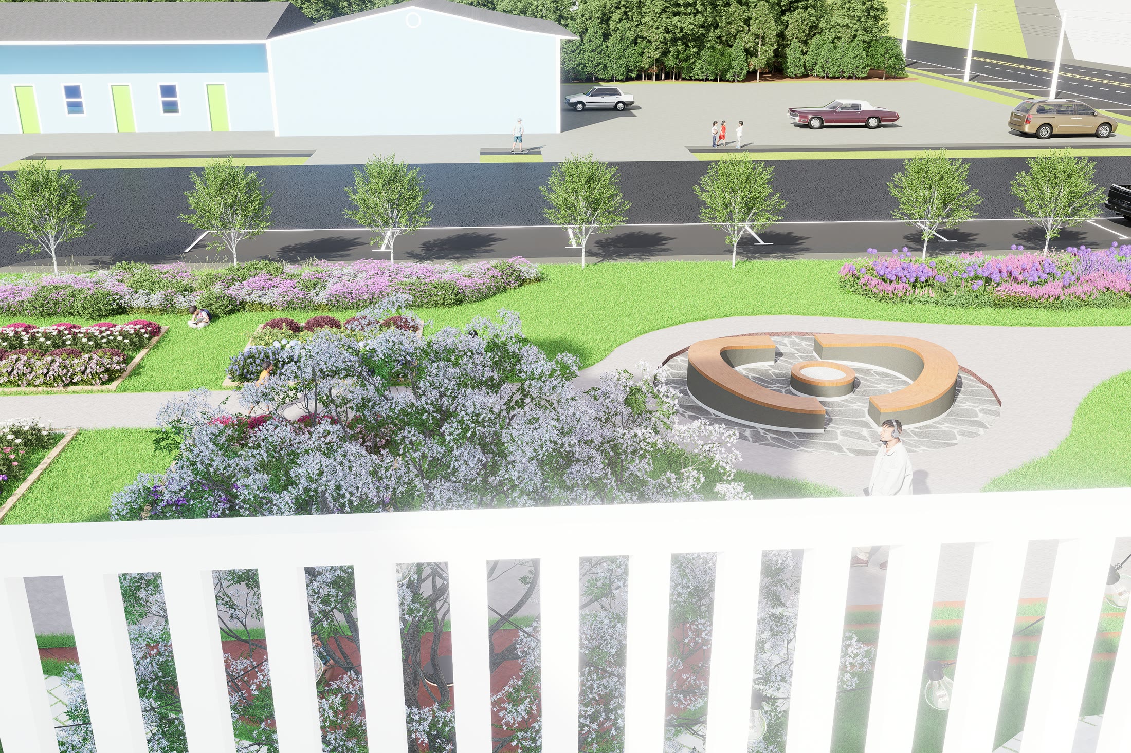 The planted garden and its circular fountain seen over the low white fence from the pavement
