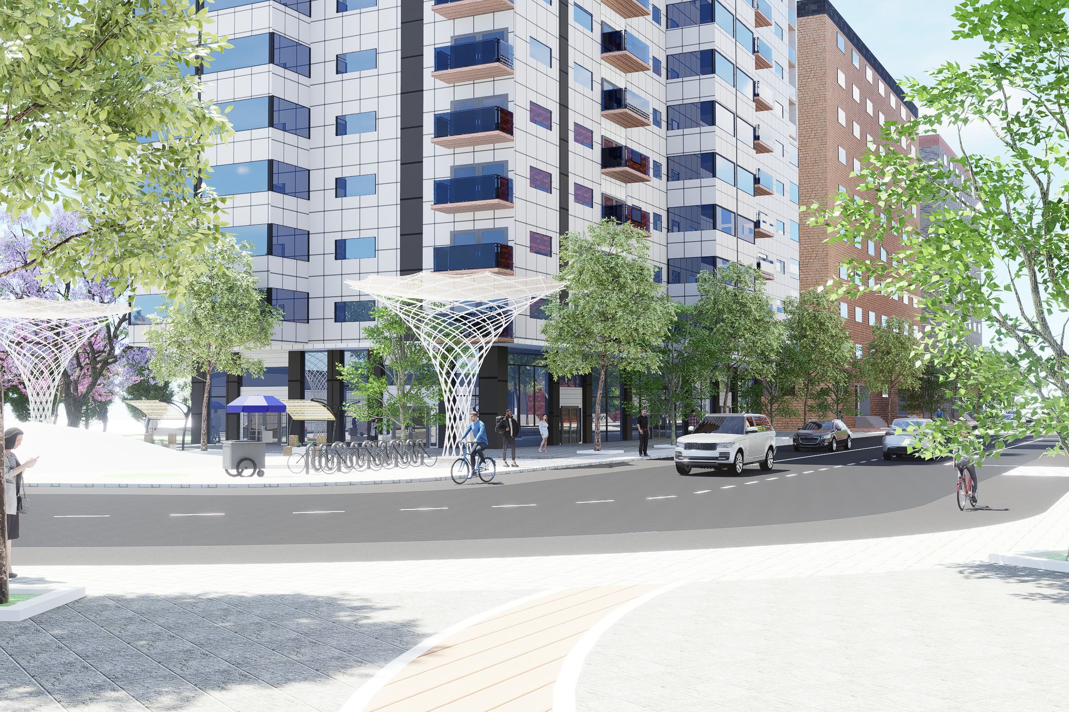The internal street with white branching canopies over the pavement, mid-rise blocks either side and a cyclist passing