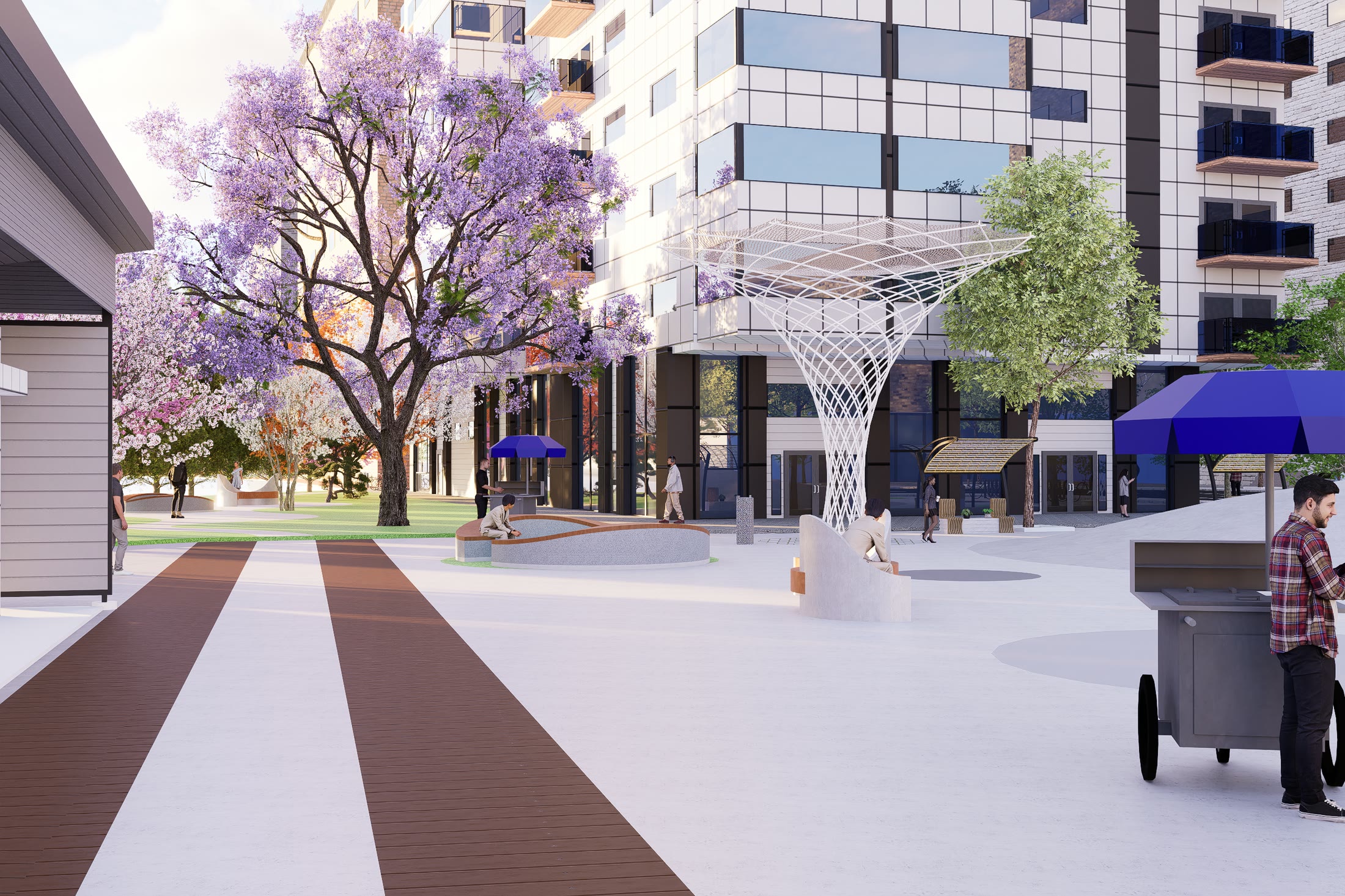 The paved route with a flowering tree, a market stall at the shopfronts and the canopy overhead