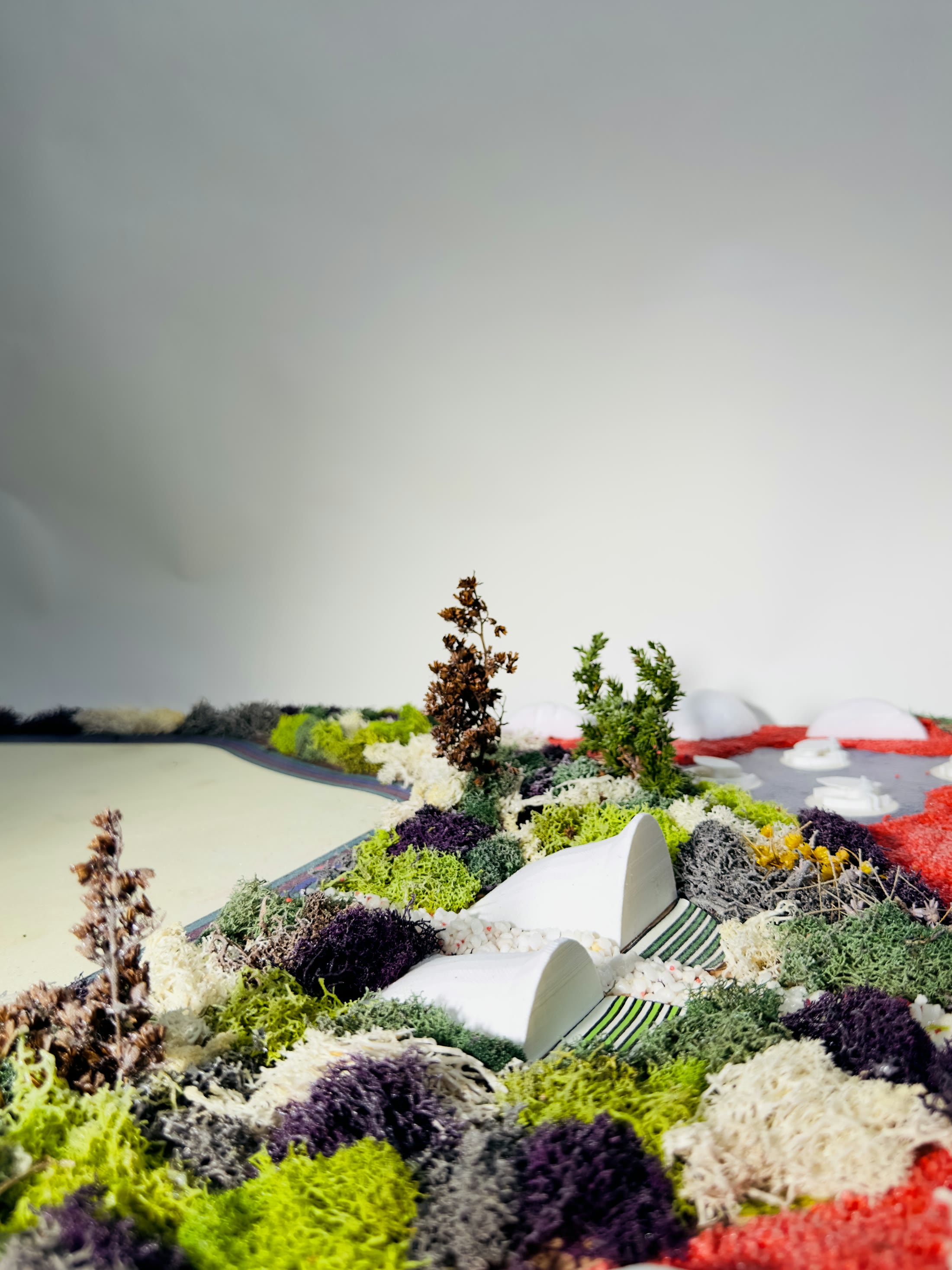 Low angle across the model with the pavilion shell against the studio wall